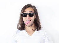 Ein junger Mann mit Sonnenbrille, der die Zunge raussstreckt